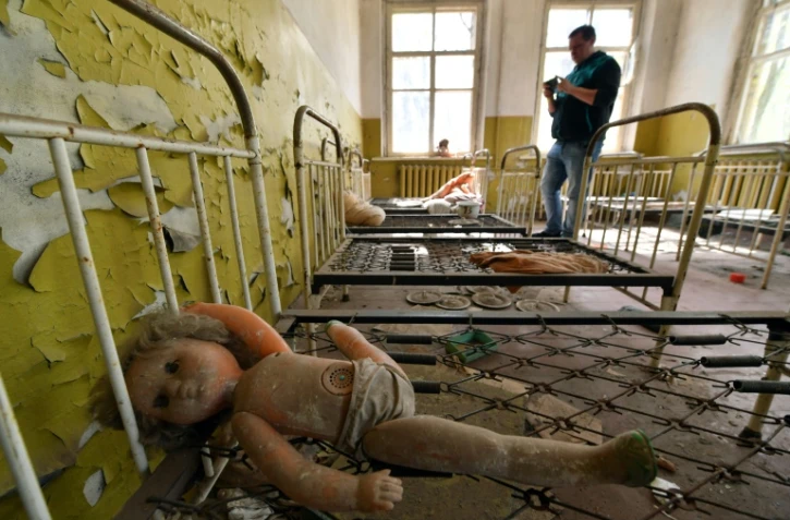 Un touriste prend des photos dans une école maternelle abandonnée dans le village de Kopachi près de la centrale de Tchernobyl le 23 avril 2018