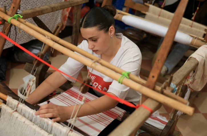 Rozana Gostorani travaille sur un métier à tisser dans un petit atelier à Dajc, dans la région de Zadrima, le 27 mai 2025 en Albanie