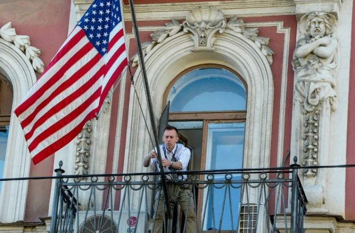 Un employé du consulat américain de Saint Pétersbourg fixe la bannière étoilée sur le balcon du consulat, le 31 mars 2018