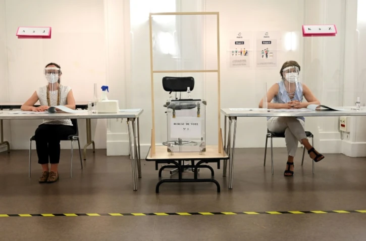 Des bénévoles dans un bureau de vote avant le second tour des municipales, à Paris le 26 juin 2020