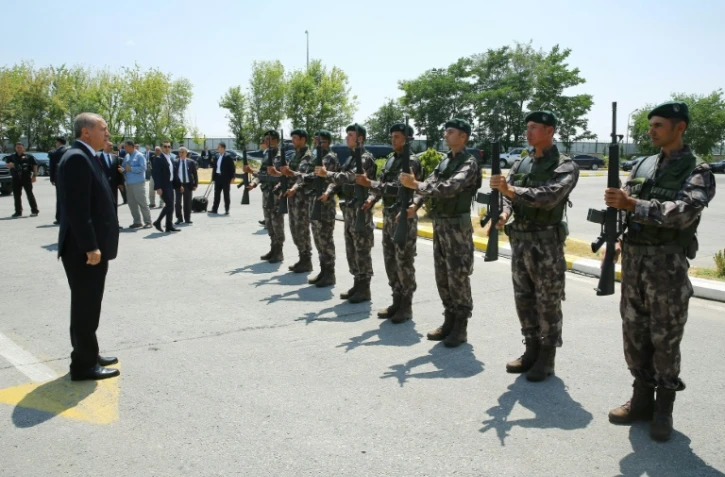 Une photo fournie par le service de presse de la présidence turque montrant le président Recep Tayyip Erdogan (g) et des membres des forces spéciales de police, le 29 juillet 2016 à Ankara
