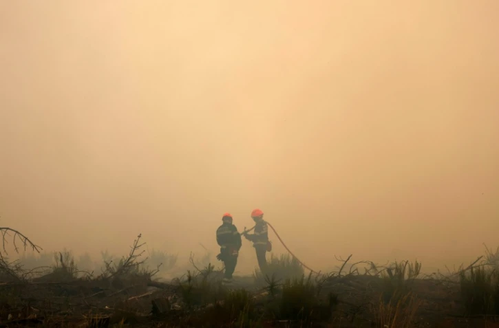 Des pompiers dans la fumée du mégafeu en Gironde, le 26 juillet 2026 à Arès
