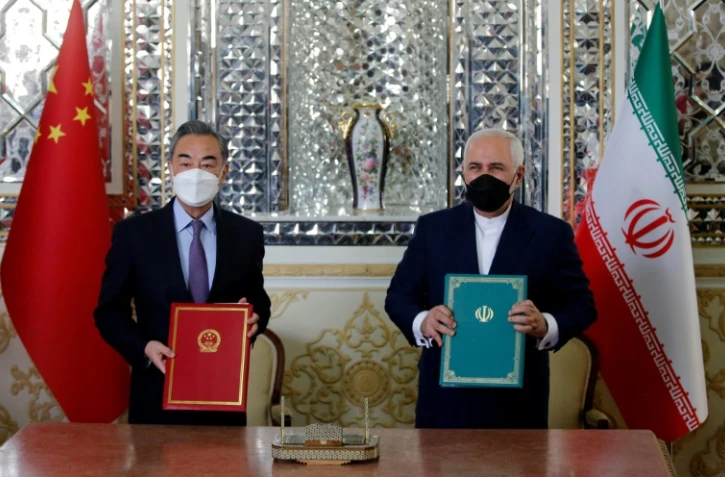 Le ministre iranien des Affaires étrangères Javad Zarif (d) et son homologue chinois Wang Yi après la signature d'un accord de coopération stratégique et commercial, le 27 mars 2021 à Téhéran