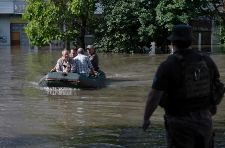 Des soldats ukrainiens évacuent des habitants de zones inondées à Kherson, le 7 juin 2023, après la destruction partielle du barrage de Kakhova
