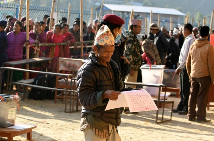 Un Népalais examine les bulletins avant de voter, le 26 novembre 2017, à Chautara, dans le district de Sindhupalchowk