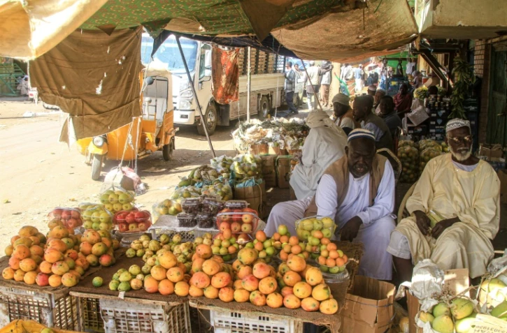 Des vendeurs de fruits assis devant leurs étals sur le marché central de Khartoum au Soudan, le 17 janvier 2025