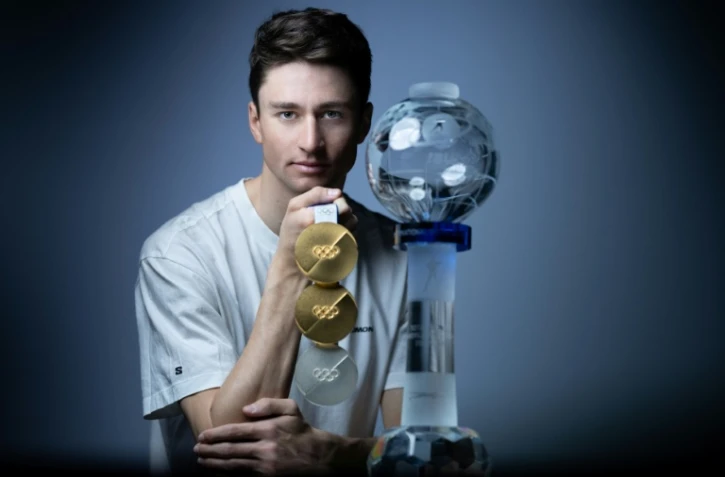 Le biathlète Éric Perrot pose avec ses trois médailles olympiques et son globe de cristal lors d'une séance photo à Paris, le 25 mars 2026