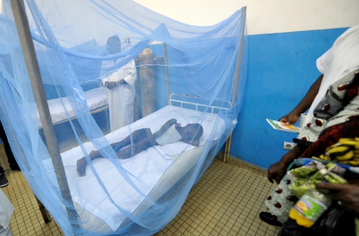 Un enfant malade se trouve dans une moustiquaire dans un hôpital d'Abidjan, le 24 avril 2015