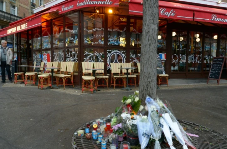 Bouquets de fleurs déposés au pied d'un arbre devant le "Comptoir Voltaire" le 16 décembre 2015 à Paris