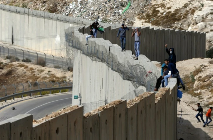 Des Palestiniens debout sur le mur séparant la ville d'Abu Dis en Cisjordanie et Jérusalem est le 28 octobre 2015