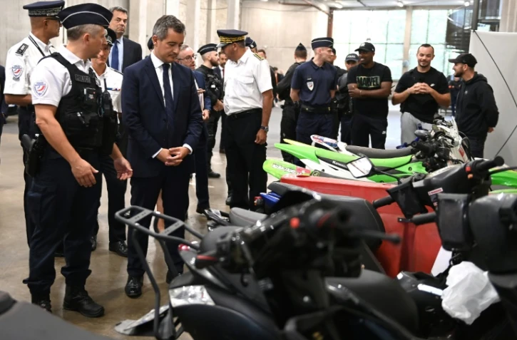 Le ministre de l'Intérieur français (4e à g) devant des deux-roues saisis par la police après des rodéos urbains à l'hôtel de police de Créteil, le 17 août 2022