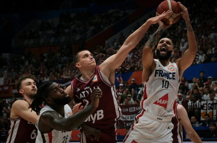 Le basketteur de l'équipe de France Evan Fournier (à droite) au duel avec le Letton Andrejs Grazulis (deuxième à droite) lors de la victoire de la Lettonie en match de poules de la Coupe du monde de basket à Jakarta, Indonésie, le 27 août 2023