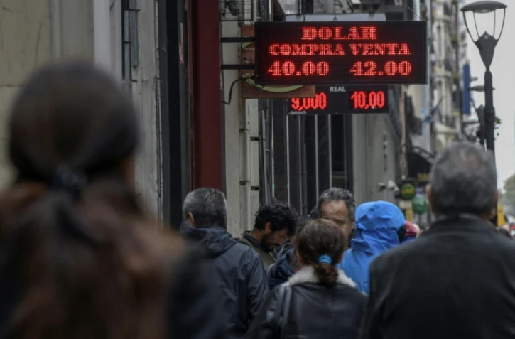 Des gens passent devant un bureau de change à Buenos Aires le 30 août 2018