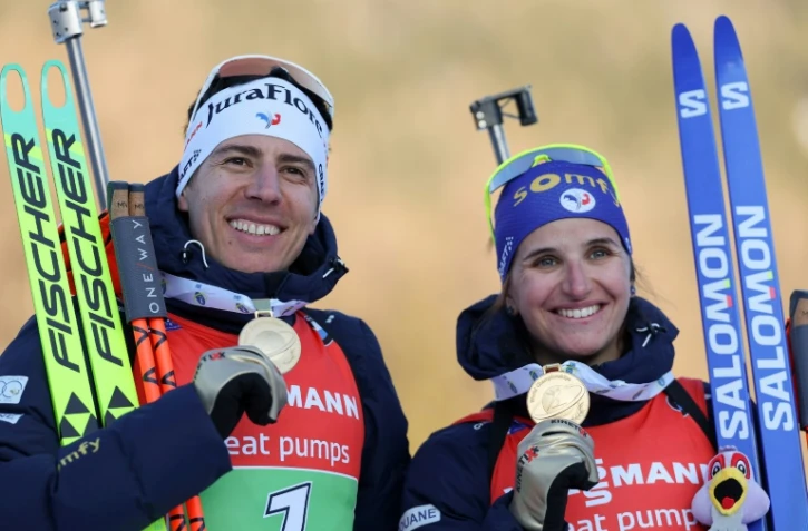 Julia Simon et Quentin Fillon Maillet posent avec leur médaille d'or du relais mixte simple des Championnats du monde de biathlon à Lenzerheide, en Suisse, le 20 février 2025