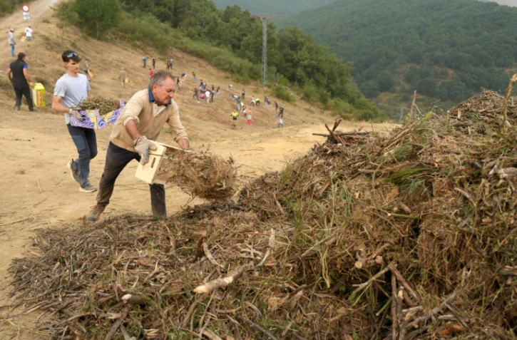 Des habitants réalisent des travaux de déboisement en prévision d'un possible arrivée du feu provenant de l'incendie du parc national des Picos de Europa, dans la ville de Riano, en Castille-et-León, en Espagne, le 18 août 2025