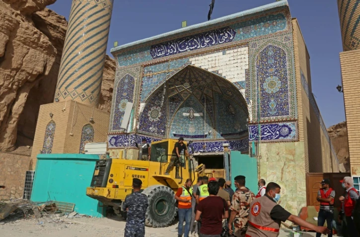 Des équipes de secours recherchent des survivants dans les décombres d'un sanctuaire chiite, le 21 août 2022 à Kerbala, en Irak