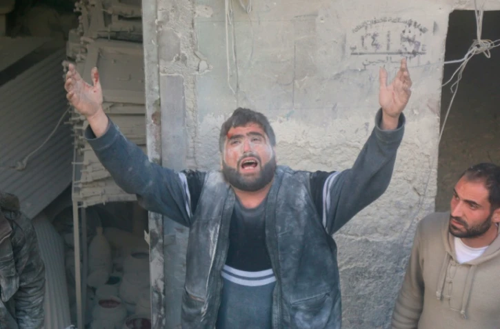 Un Syrien appelle à l'aide après un raid aérien contre une zone d'Alep détenue par les rebelles, le 11 mars 2016