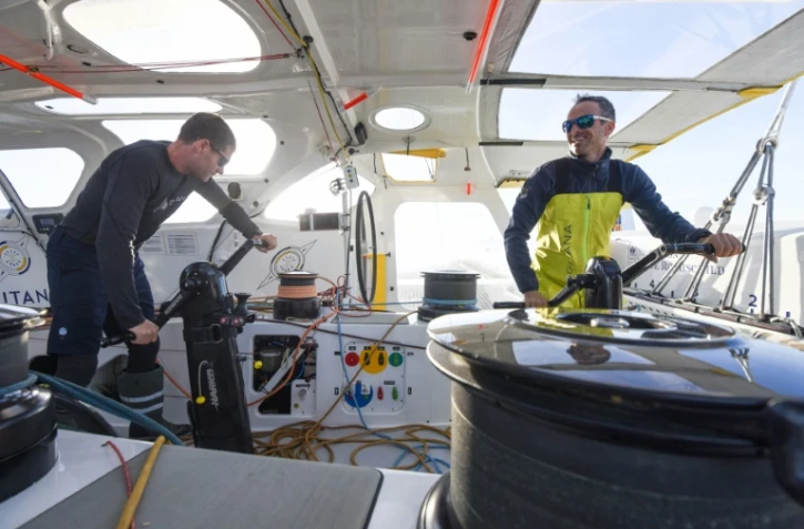Les skippers Franck Cammas (à droite) et Charles Caudrelier, à la barre de leur maxi-trimaran Maxi "Edmond de Rothschild" au large de Lorient, le 27 octobre 2021, ont coupé la ligne les premiers de la catégorie Ultim de la Transat Jacques Vabre 