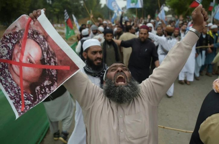 Un partisan du parti musulman extrémiste ASWJ (Ahle Sunnat Wal Jamaat) proteste contre l'acquittement de la chrétienne Asia Bibi dont il brandit le portrait barré de rouge, à Islamabad le 2 novembre 2018