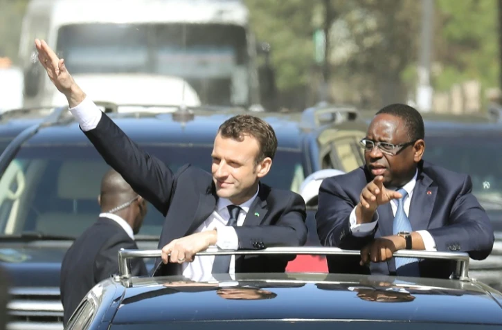 Emmanuel Macron, au côté du président sénégalais Macky Sall, salue la foule lors de sa visite à Dakar le 2 février 2018
