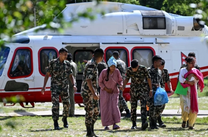 Des militaires soutiennent une rescapée, au camp de Trishuli, dans le district de Nuwakot au Népal, le 28 août 2026