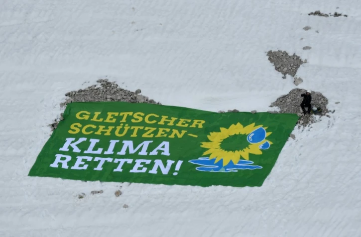 Un militant des Verts allemands déploie une banderole réclamant: "protégez les glaciers - sauvez le climat!" sur la plus haute montagne allemande, le 7 mai 2018 