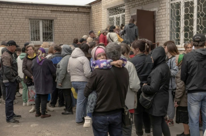 Des habitants qui ont fui différentes zones de la région de Kharkiv, attendent d'être enregistrés à un point d'évacuation, le 14 mai 2024 à Kharkiv, dans le nord-est de l'Ukraine