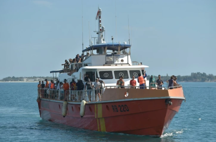 Des touristes évacués des îles de Gili arrivent au port de Bangsal, le 7 août 2018 après un séisme sur l'île de Lombok, en Indonésie