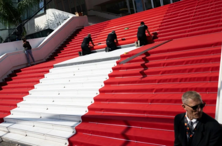 Pose du tapis rouge sur les marche du palais du festival, à Cannes, le 17 mai 2022