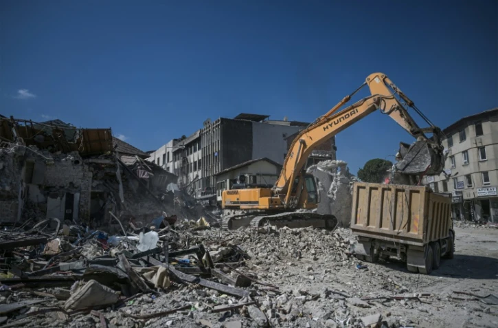 Une pelleteuse déblaie les décombres de bâtiments historiques détruits par le séisme du 6 févier, le 10 juillet 2023 à Antakya, en Turquie