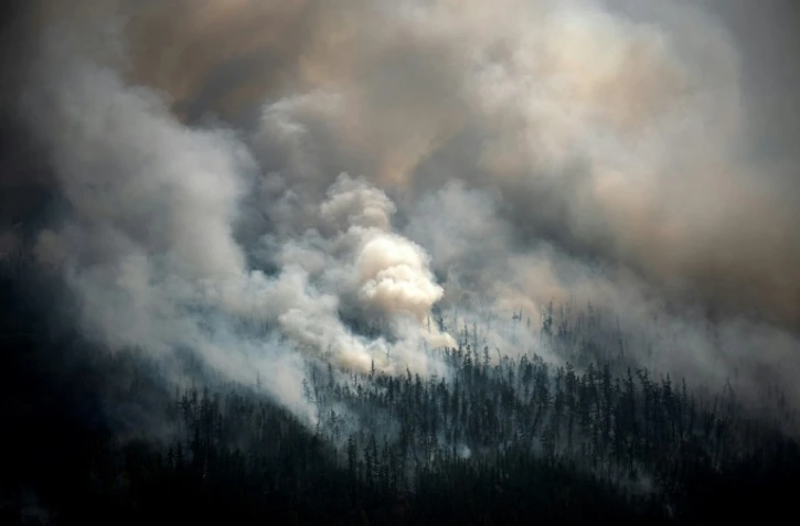 Vue aérienne prise depuis un avion le 27 juillet 2021, montrant la fumée s'élevant d'un feu de forêt à l'extérieur du village de Berdigestyakh, dans la république de Sakha, en Sibérie