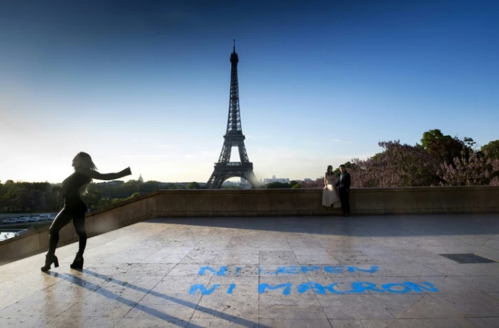 Un couple pose au Trocadero devant la tour Eiffel à Paris, sur le sol est inscrit le slogan "ni Le Pen ni Macron", le 27 avril 2017
