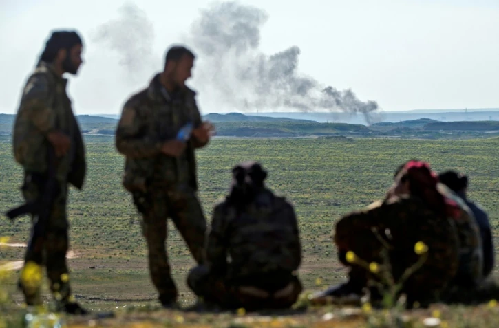 Une colonne de fumée s'élève dans le ciel du village de Baghouz, dans la province de Deir Ezzor (est), le 12 février 2019, durant l'offensive "finale" des Forces démocratiques syriennes (FDS) contre l'ultime réduit du groupe jihadiste Etat islamique (EI) en Syrie