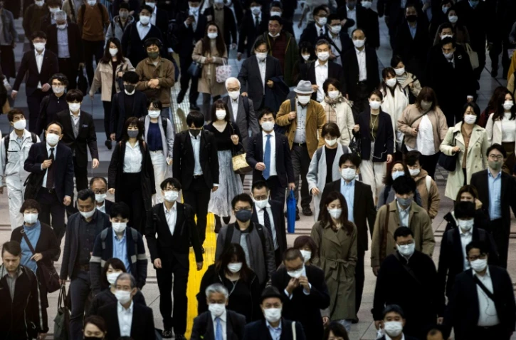 Des usagers des transports portent le masque Ă la gare de Shinagawa Ă Tokyo, le 19 novembre 2020