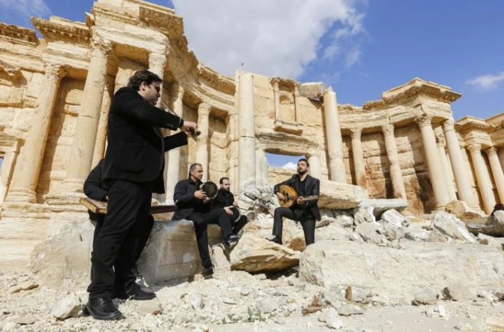 Des musiciens syriens jouent sur la scène du théâtre antique de Palmyre, le 4 mars 2017 lors d'une visite organisée par l'armée syrienne pour les journalistes
