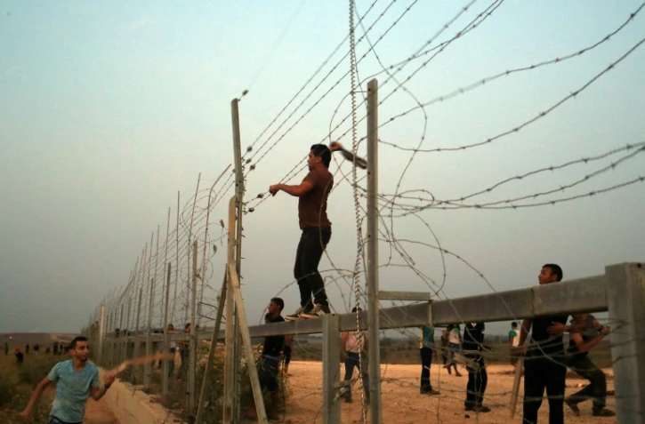 Des Palestiniens s'attaquent aux barbelés à la frontière entre Gaza et Israël, lors d'affrontements avec les forces de l'ordre israéliennes le 12 octobre 2015