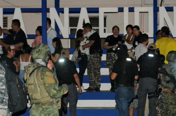 Des personnels pénitentiaires (g), retenus en otage par des détenus de la prison de Machala, retrouvent leurs proches après leur libération, le 13 janvier 2024 en Equateur
