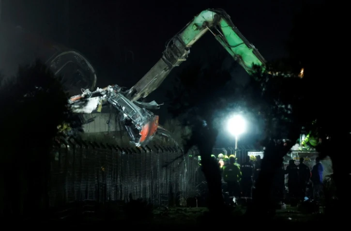 Des wagons endommagés sont retirés à l’aide d’engins lourds sur les lieux d’une collision ferroviaire entre deux trains à grande vitesse, entre Urda et Los Yébenes, dans la province de Tolède, le 28 octobre 2026 en Espagne