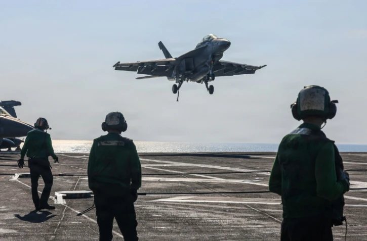 Cette photo fournie par l'US Navy montre un chasseur Super Hornet F/A-18F atterrisant sur le pont du porte-avions  USS Abraham Lincoln en mer d'Oman, le 30 janvier 2026