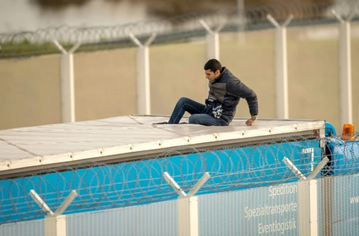 Un migrant est monté sur le toit d'un camion à Calais à l'entrée du tunnel sous la Manche pour pouvoir se rendre clandestinement en Grande-Bretagne, le 17 décembre 2015