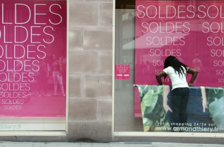 Une femme attend devant un magasin à la veille du début des soldes d'été, à Strasbourg le 21 juin 2016