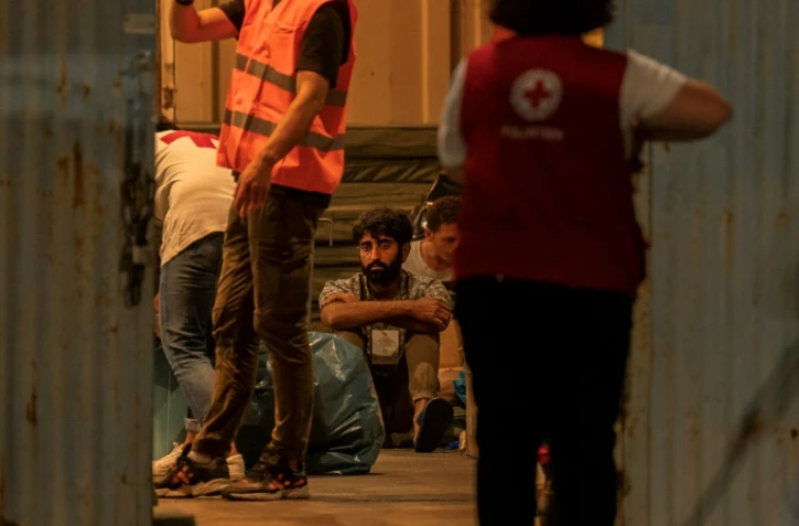 Des migrants, rescapés d'un naufrage, attendent dans le port de Kalamata, le 14 juin 2023 en Grèce