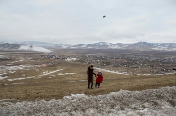 Amina, 5 ans, et sa mère se promènent à Bornuur Sum, un village à 135 km d'Oulan-Bator où s'est réfugiée la fillette pour échapper à la pollution de la capitale mongole, le 23 février 2019
