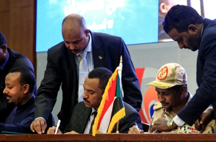Le meneur de la contestation Ahmed al-Rabie (C), et le général Mohammed Hamdan Daglo (D), numéro deux du Conseil militaire soudanais, signent un accord de transition, à Khartoum, le 17 août 2019