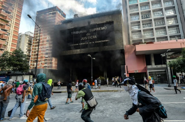 Des manifestants s'enprennent au bâtiment de la Cour suprême de Justice, le 12 juin 2017 à Caracas