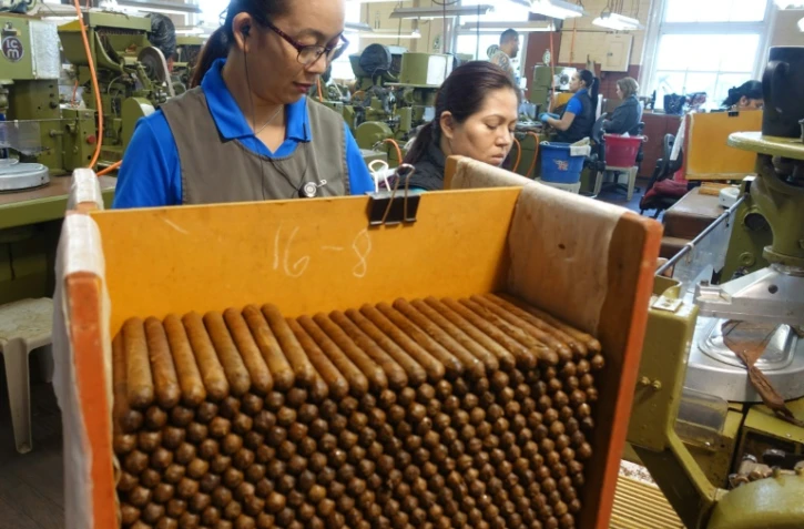 Des employés de la fabrique de cigares de J.C. Newman, travaillent sur des machines très anciennes, à Tampa en Floride le 21 avril 2016