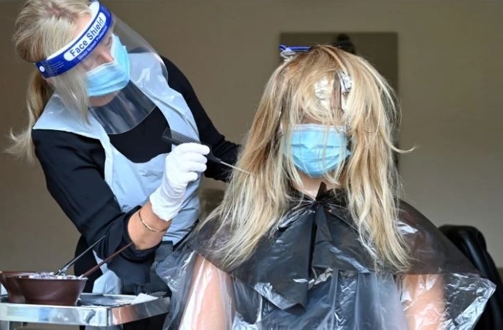 Kerry Clegg s'occupe des cheveux d'une cliente à Birkenhead (nord-ouest) le 4 juillet 2020