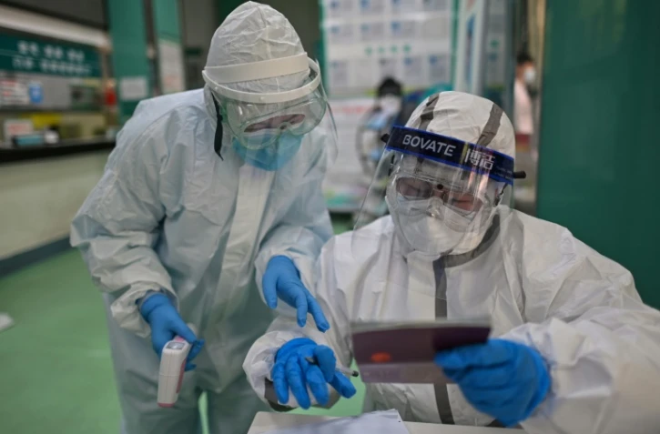 Des personnels médicaux vérifient des informations  des tests de Covid-19 qu'ils font passer aux habitants de Wuhan, le 16 avril 2020