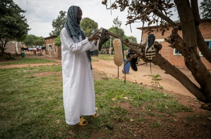 Le Sud-Soudanais Ismail Hmdan Banaga fait sécher ses chaussures au centre de transit de Gashora, le 10 juin 2022