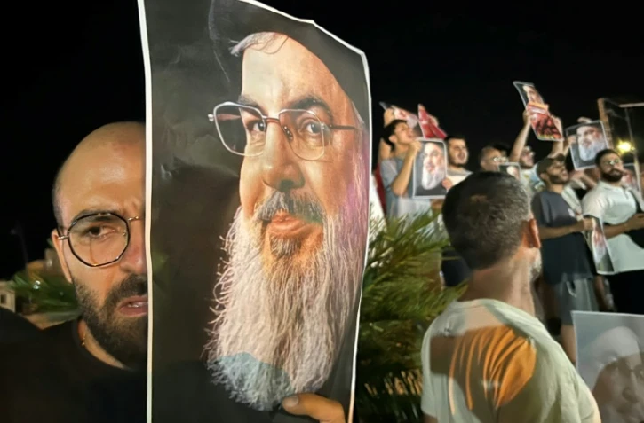 Des manifestants brandissent des portraits du chef du Hezbollah Hassan Nasrallah, le 28 septembre 2024 à Sidon, dans le sud du Liban